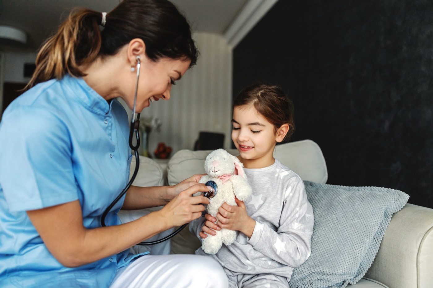 A child playing at home with a care provider nearby