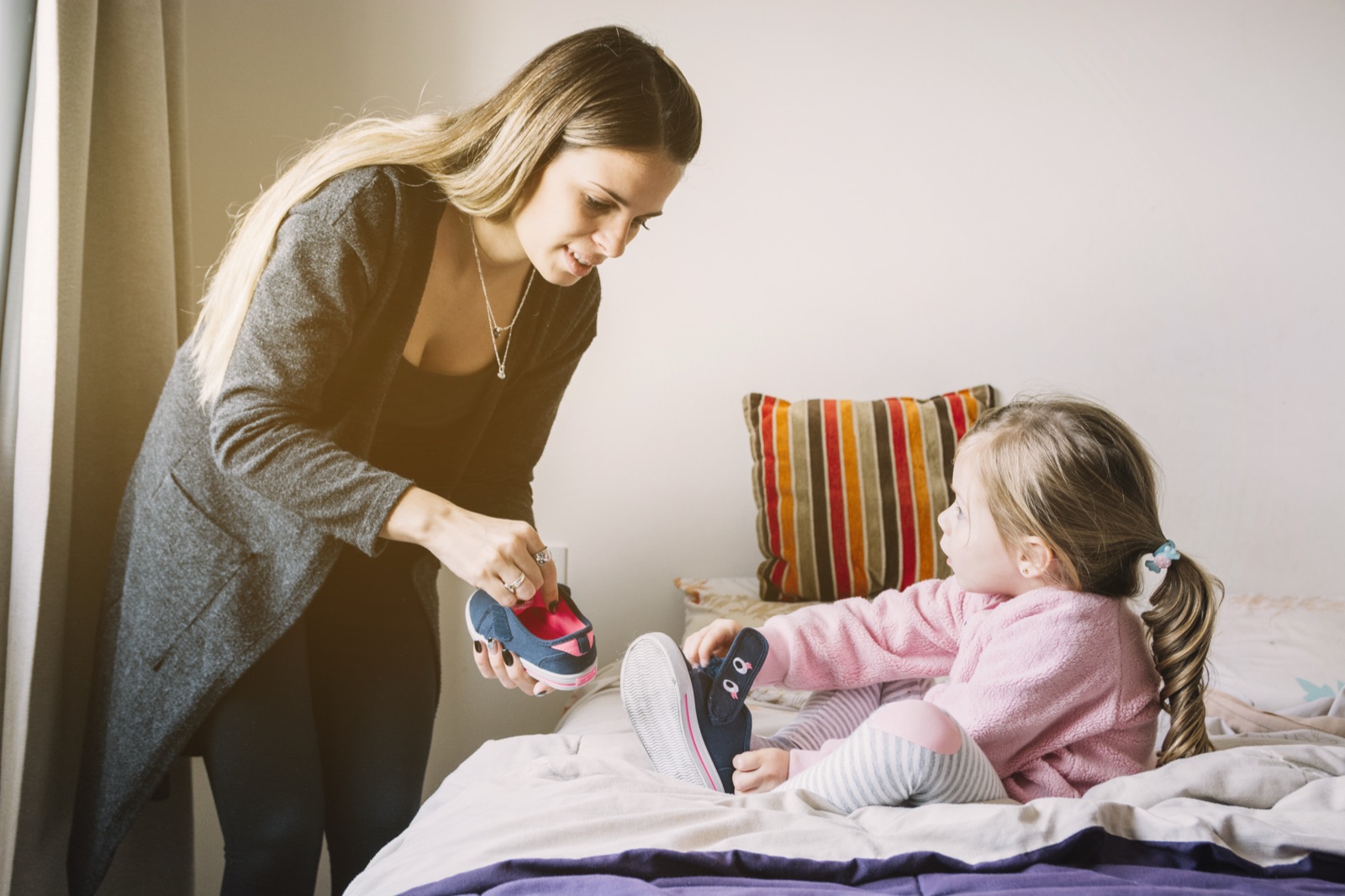 A parent helping their child get ready at home